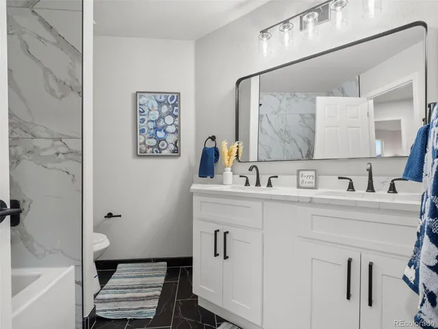 a kitchen with stainless steel appliances granite countertop a sink a stove and a wooden floors