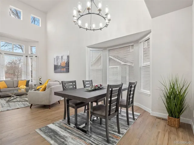 a kitchen with a sink a stove a refrigerator and white cabinets with wooden floor