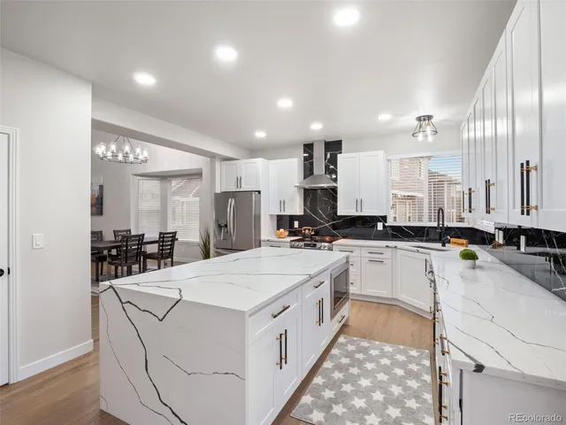 a kitchen with a dining table chairs and white cabinets