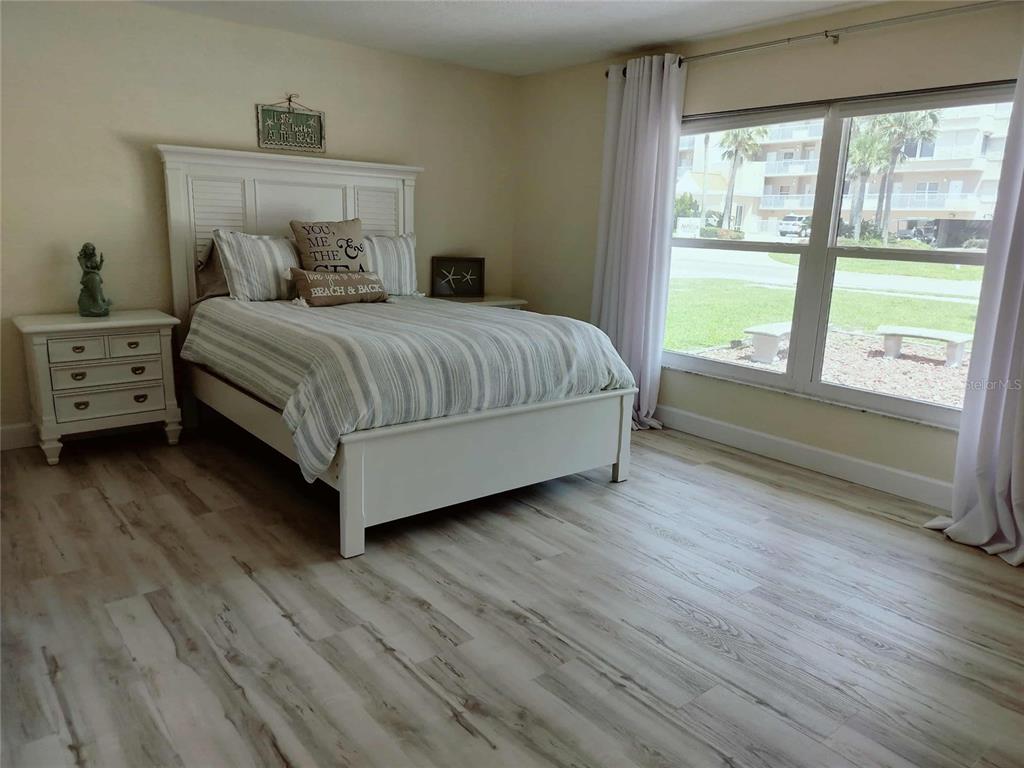 4766 South Atlantic Avenue Ponce Inlet, FL 32127 - Photo 16 of 32 a bedroom with a large bed and a large window