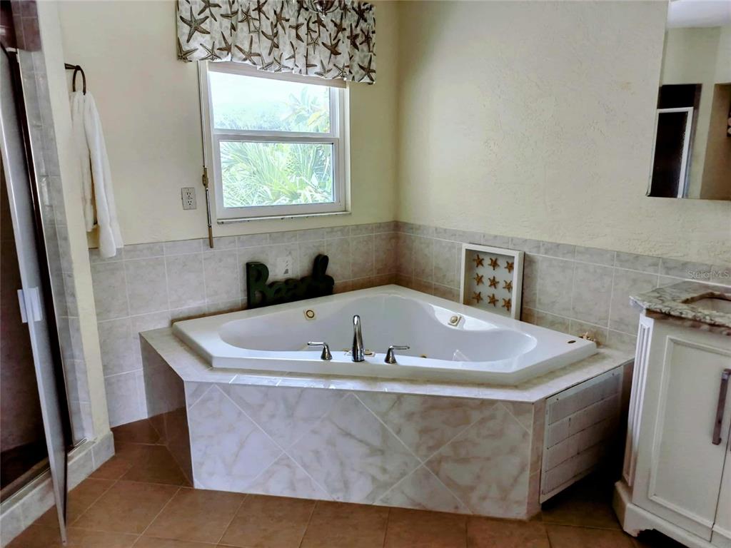 4766 South Atlantic Avenue Ponce Inlet, FL 32127 - Photo 17 of 32 a bath tub sitting in a bathroom next to a window