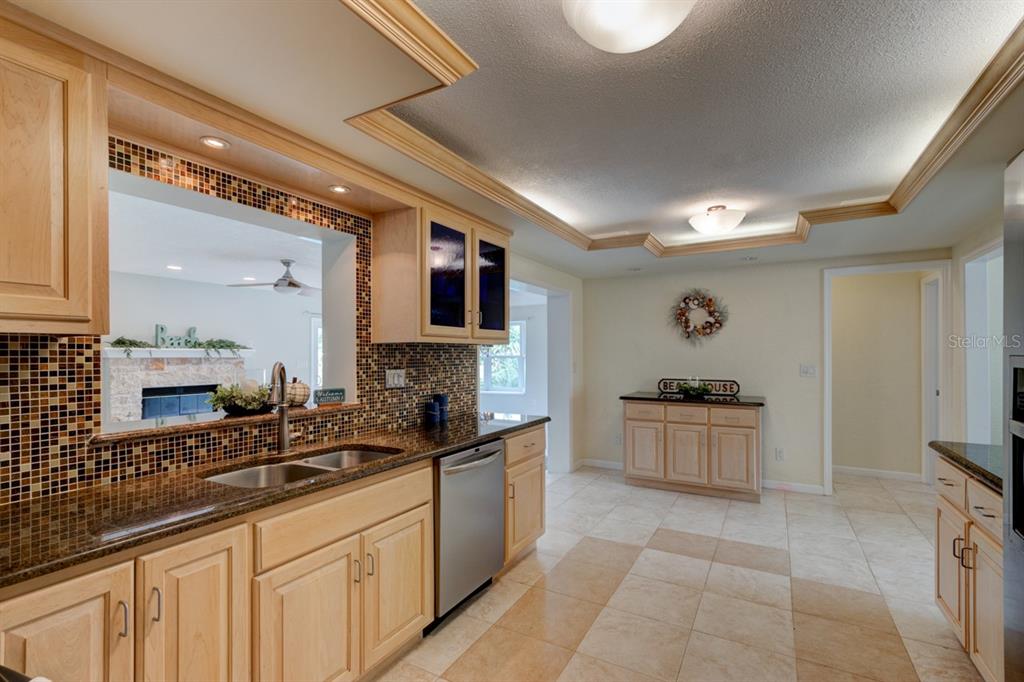 4766 South Atlantic Avenue Ponce Inlet, FL 32127 - Photo 7 of 32 a kitchen with granite countertop a sink stove and cabinets