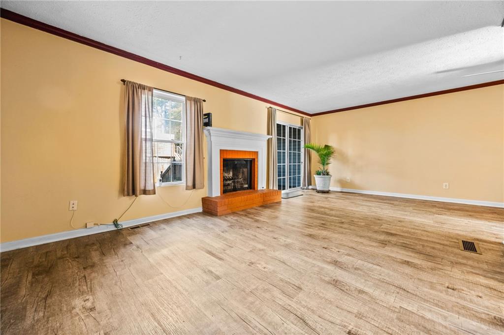 805 Manning Way Southwest Marietta, GA 30064 - Photo 21 of 35 an empty room with wooden floor fireplace and windows
