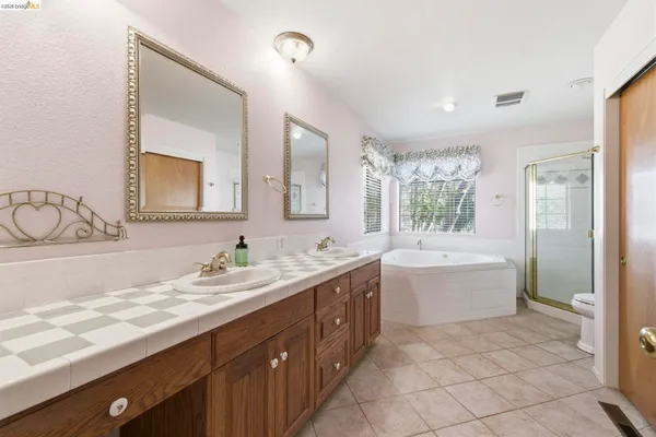 a bathroom with a granite countertop sink mirror and bathtub