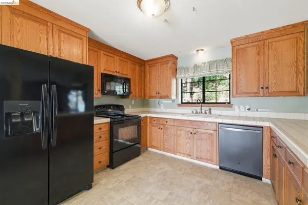 a kitchen with stainless steel appliances granite countertop a refrigerator a stove a sink and a microwave