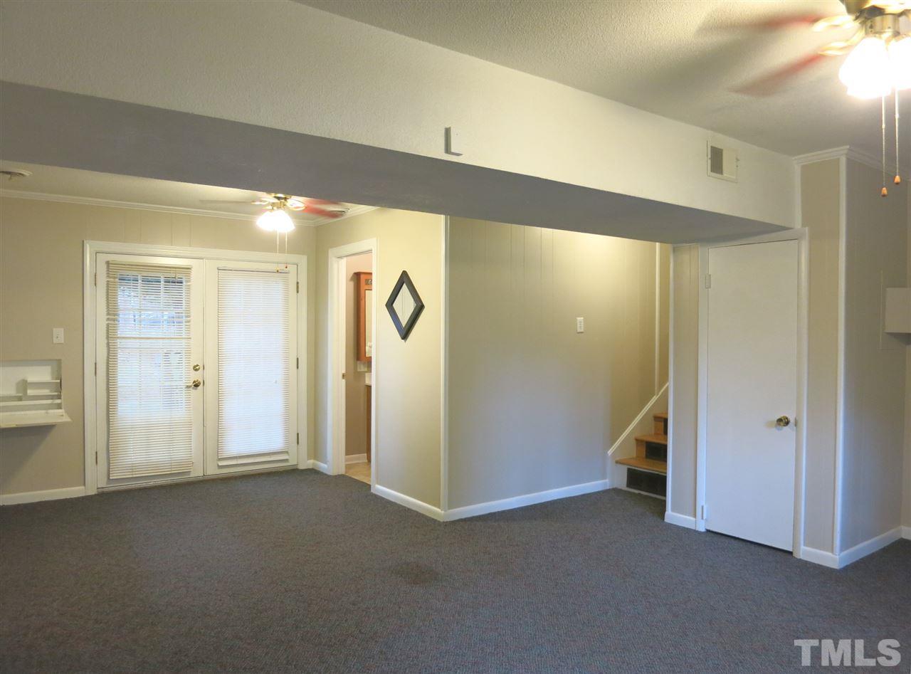 5201 Knollwood Road Raleigh, NC 27609 - Photo 12 of 25 The lg lower level Family Rm offers carpet, 2 CFs, crown molding, painted paneled walls, built-in drop-down desk, bookshelves & French doors to the backyard.