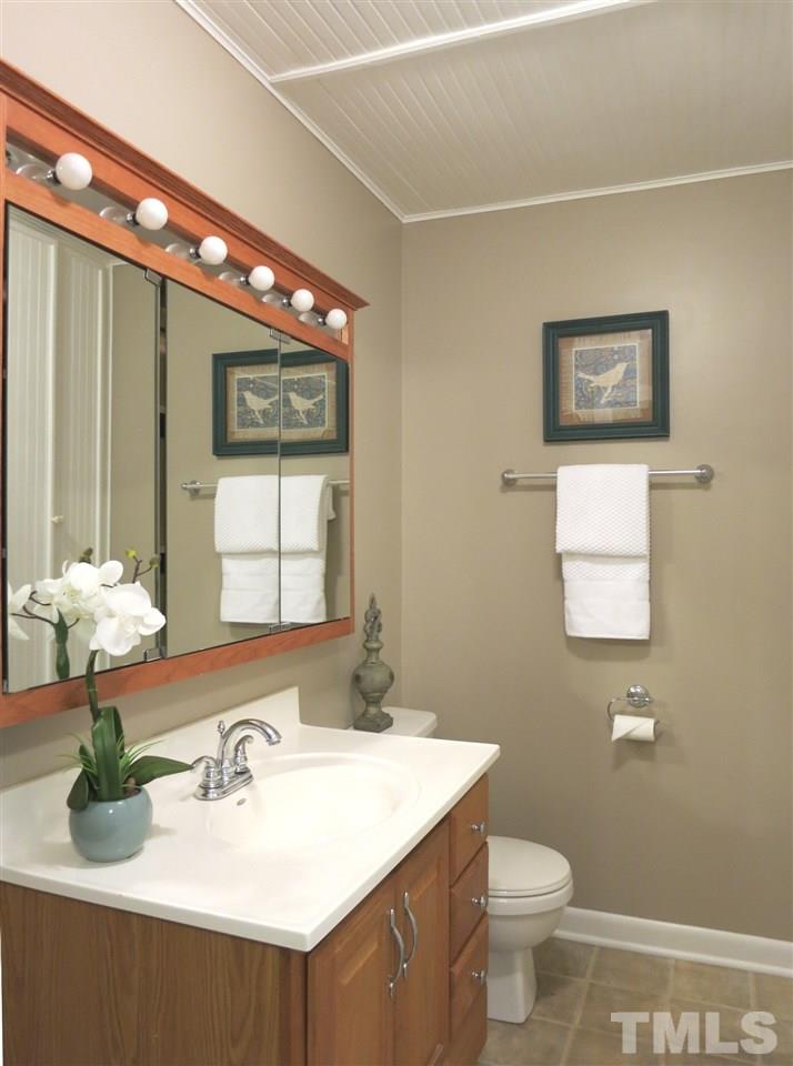 5201 Knollwood Road Raleigh, NC 27609 - Photo 14 of 25 The lower level full Bath has a neutral vinyl floor, tall linen cabinet, tub/shower, mirrored medicine cabinet & bead board ceiling.