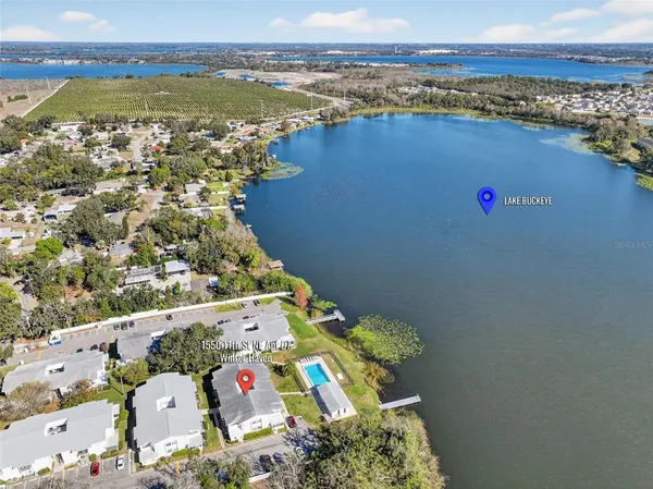 an aerial view of ocean and residential houses with outdoor space
