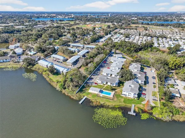 an aerial view of residential houses with outdoor space and lake view
