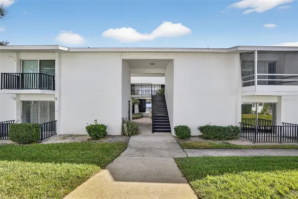 a front view of a house with a yard and potted plants