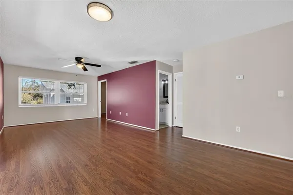 an empty room with wooden floor and windows
