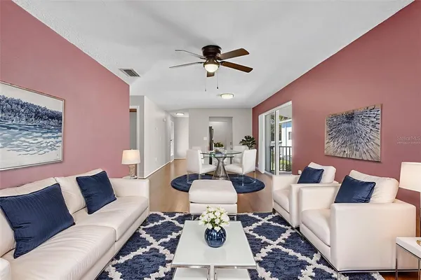 a living room with furniture a chandelier and a rug