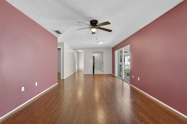 a view of a livingroom with a ceiling fan and hardwood floor