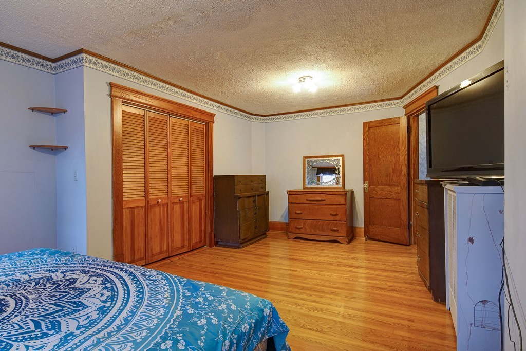 86 Osborne Terrace Springfield, MA 01104 - Photo 18 of 30 a bedroom with a bed and wooden floor