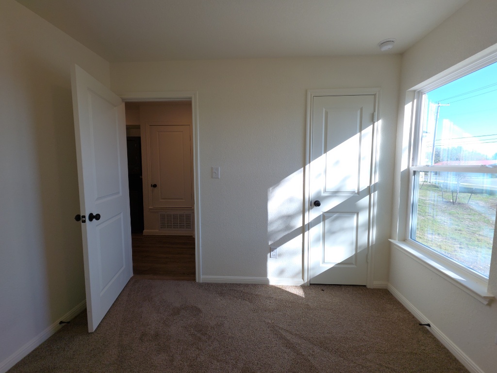 2002 West 2nd Street, Unit 100 Taylor, TX 76574 - Photo 15 of 16 Unfurnished bedroom with light colored carpet and a closet
