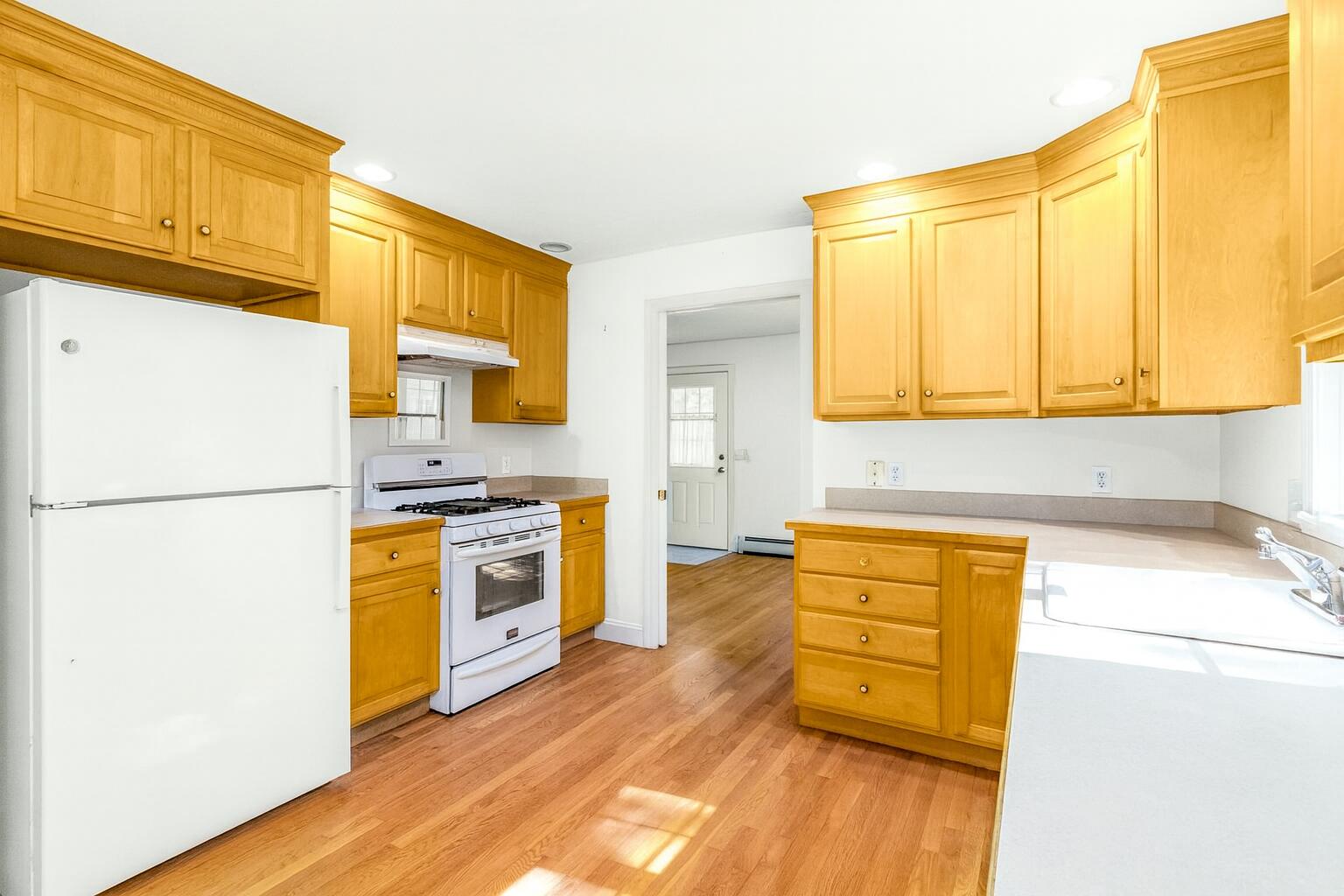 49 Rivers End Road East Falmouth, MA 02536 - Photo 10 of 32 a kitchen with stainless steel appliances a stove a sink and a refrigerator with wooden floor