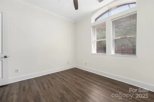 an empty room with wooden floor and white walls