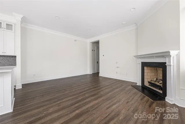 an empty room with wooden floor a ceiling fan and windows