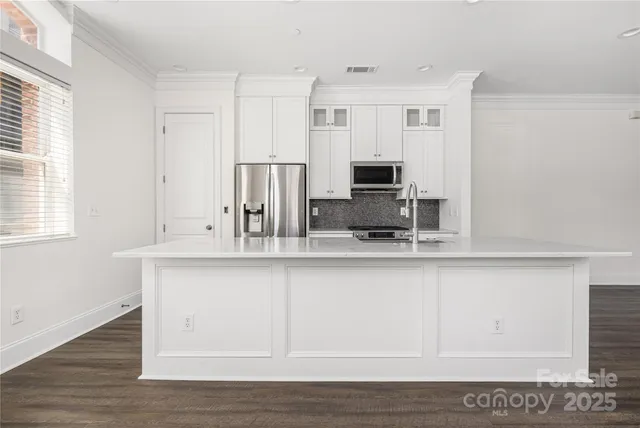 a view of a kitchen sink and wooden floor
