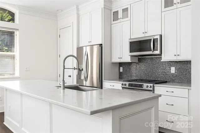 a kitchen with stainless steel appliances granite countertop a sink and stove top oven