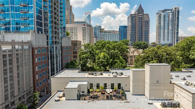 an aerial view of residential house with outdoor space and trees all around