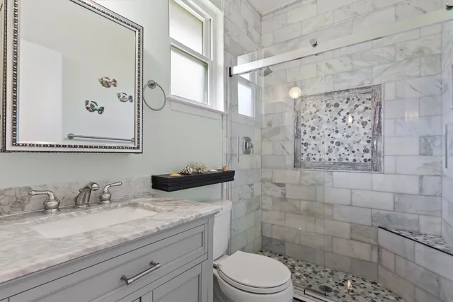 a bathroom with a granite countertop sink a toilet and a mirror