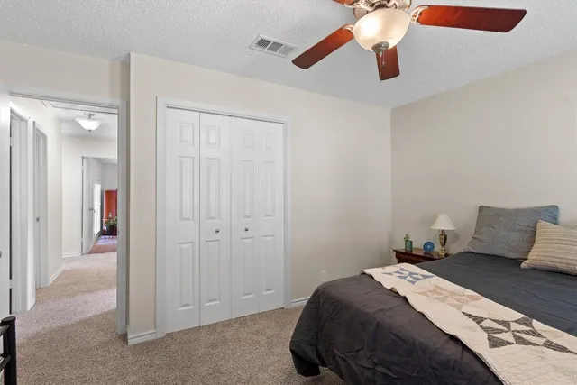 a bedroom with a bed and a ceiling fan