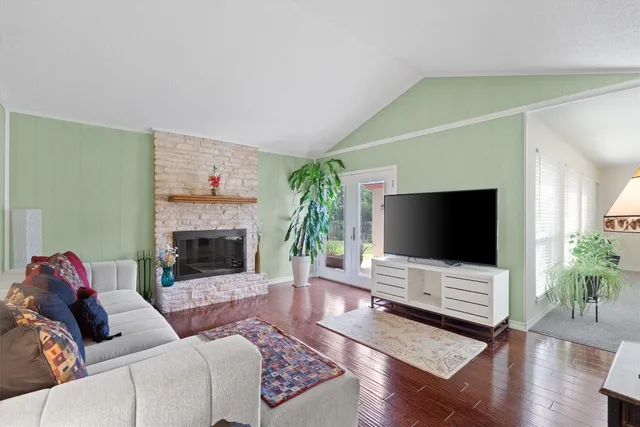 a living room with furniture a flat screen tv and a fireplace
