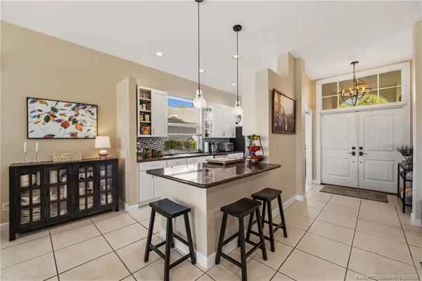 a kitchen with stainless steel appliances kitchen island granite countertop a sink and a refrigerator