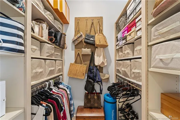 a view of walk in closet with clothes and shoes
