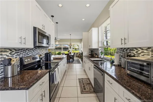 a kitchen with stainless steel appliances granite countertop a stove a sink and a granite counter tops