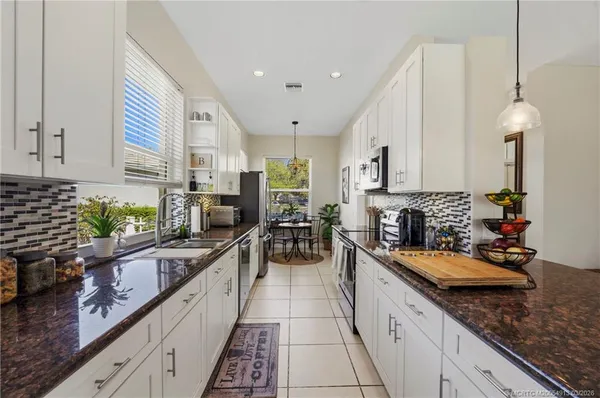 a large kitchen with a lot of cabinets appliances and a counter top space