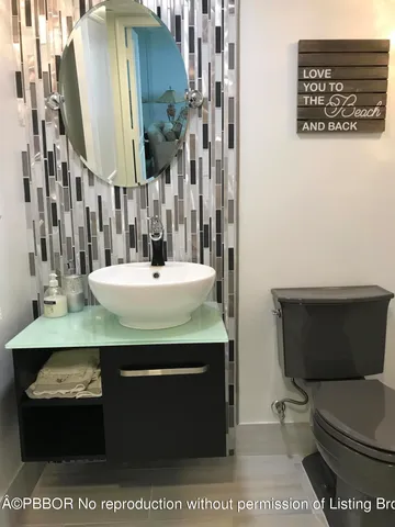 a bathroom with a sink a toilet and mirror