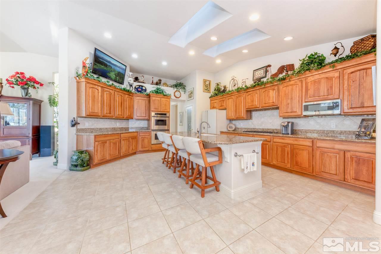 1352 Wolf Run Road Reno, NV 89511 - Photo 15 of 25 a kitchen with stainless steel appliances kitchen island granite countertop a stove a sink and a refrigerator