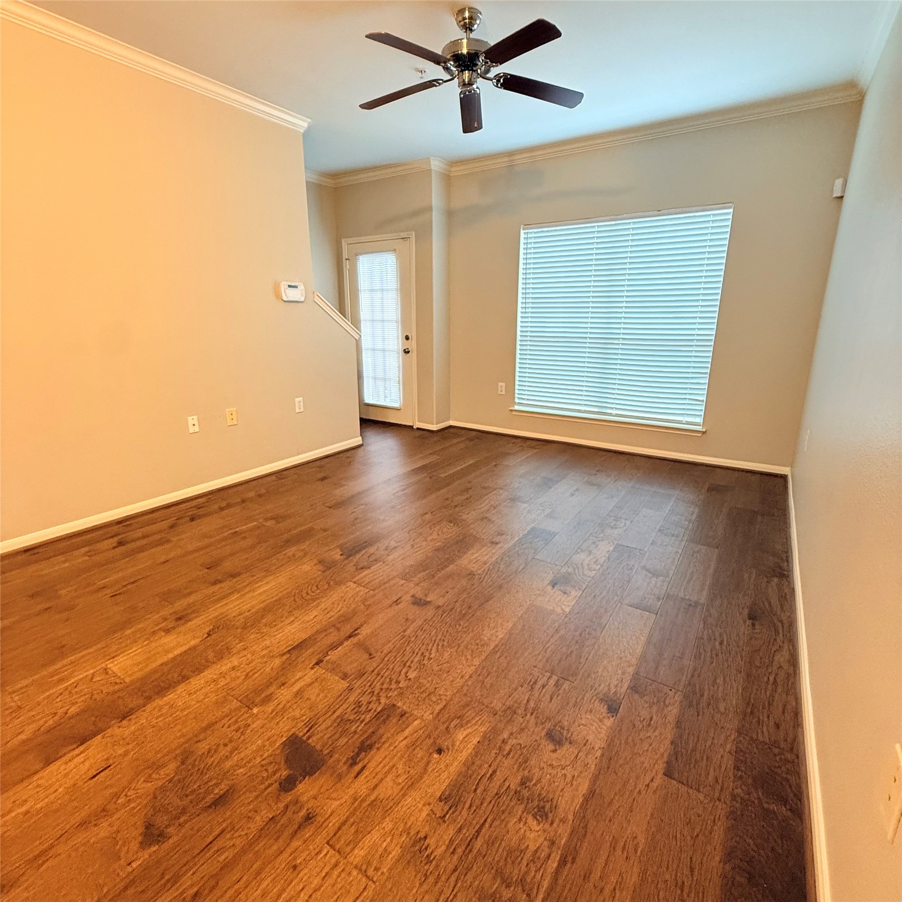 9200 Westheimer Road, Unit 304 Houston, TX 77063 - Photo 5 of 24 an empty room with wooden floor fan and windows