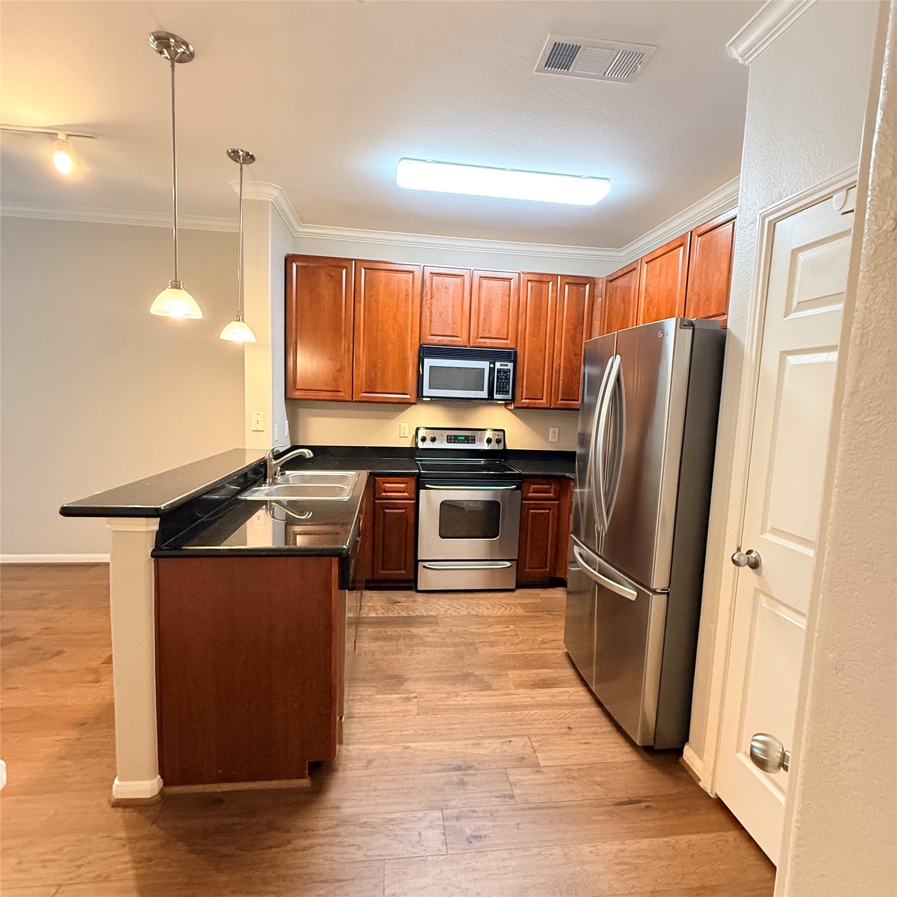 9200 Westheimer Road, Unit 304 Houston, TX 77063 - Photo 7 of 24 a kitchen with stainless steel appliances granite countertop a refrigerator a stove a sink and a wooden floors