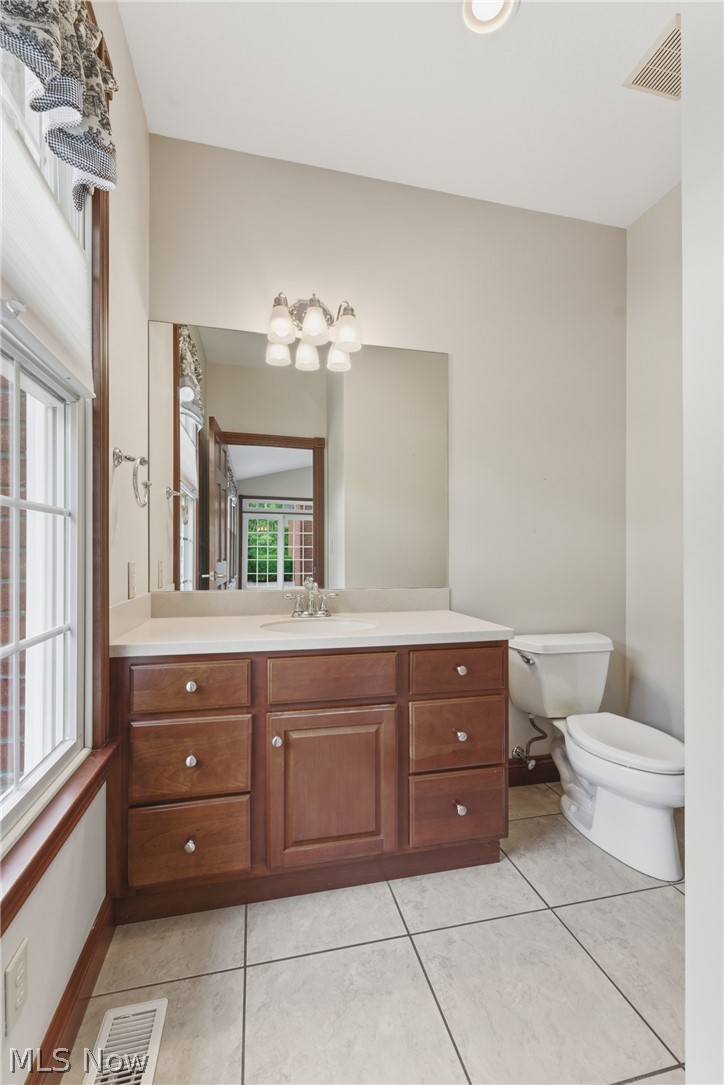 2184 Brenner Road Northeast Carrollton, OH 44615 - Photo 12 of 50 Bathroom featuring a wood-finish vanity with ample storage, a white countertop, and a large wall-mounted mirror