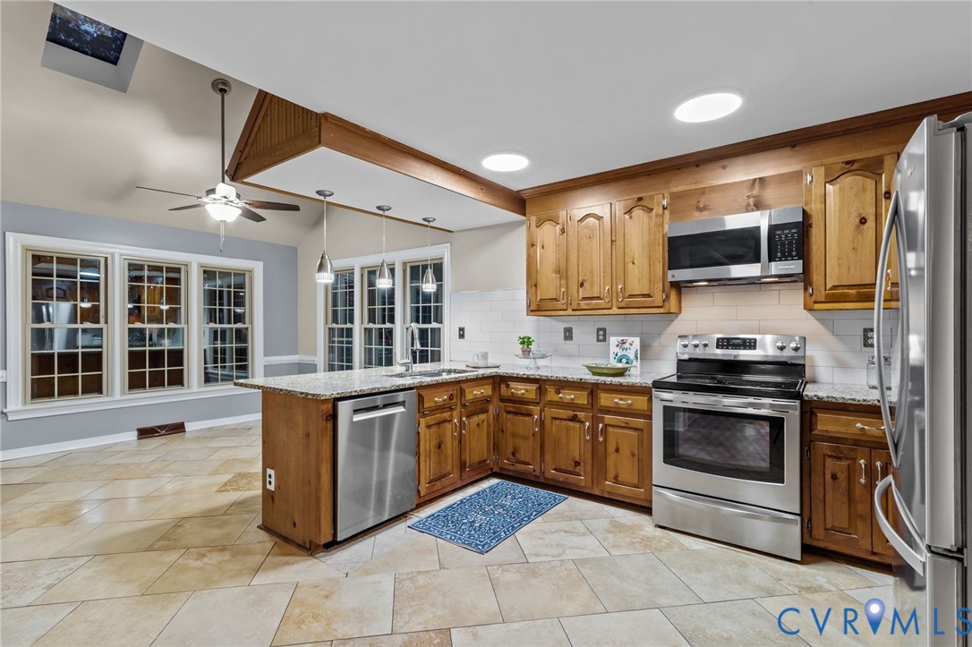 12601 Cottage Mill Road Midlothian, VA 23114 - Photo 48 of 50 a kitchen with stainless steel appliances granite countertop a stove top oven a sink and a microwave