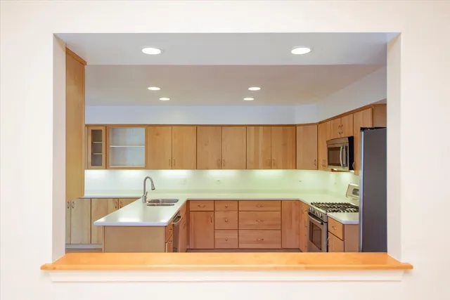 a large kitchen with stainless steel appliances granite countertop a stove a sink and a refrigerator