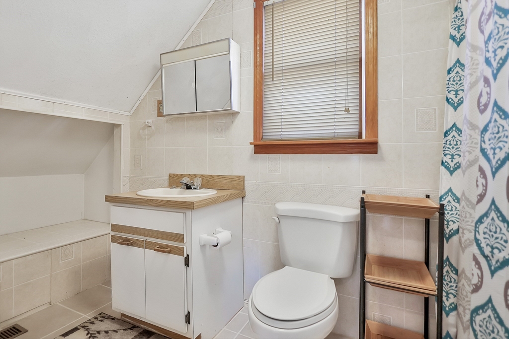 11 Warwick Street, Unit 3 Lowell, MA 01851 - Photo 16 of 23 a bathroom with a toilet sink and mirror