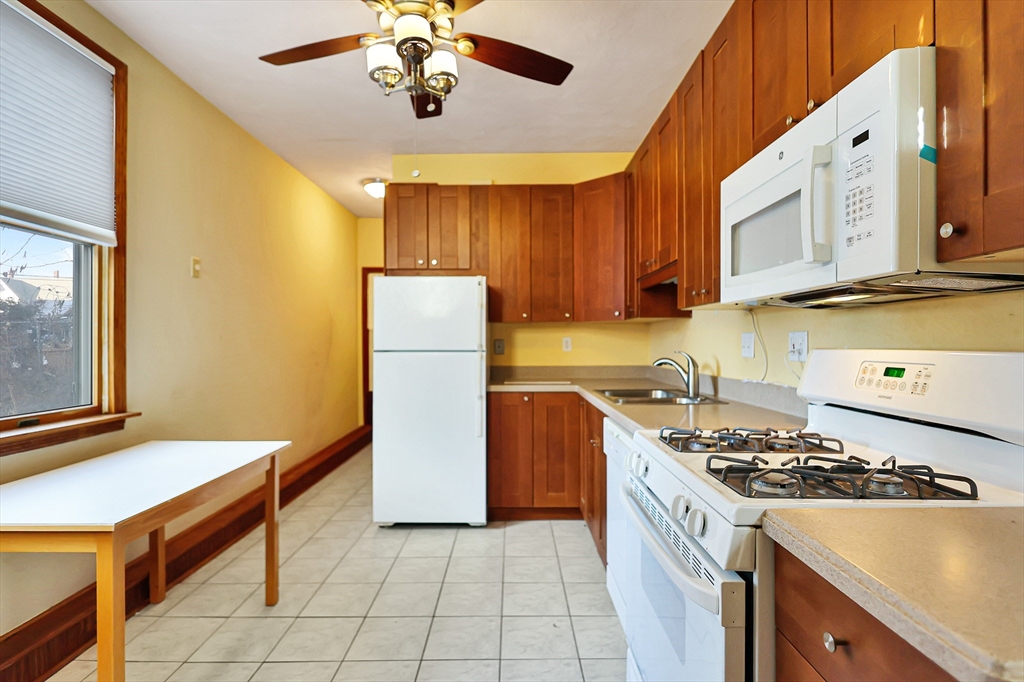 11 Warwick Street, Unit 3 Lowell, MA 01851 - Photo 4 of 23 a kitchen with a stove a sink and a refrigerator