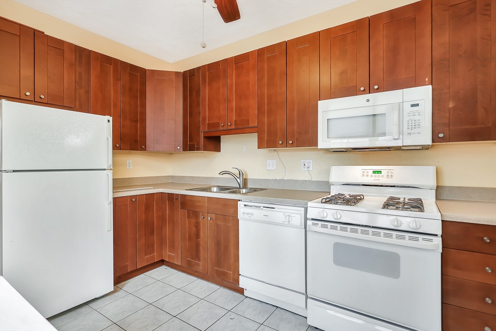 11 Warwick Street, Unit 3 Lowell, MA 01851 - Photo 5 of 23 a kitchen with a stove sink and cabinets