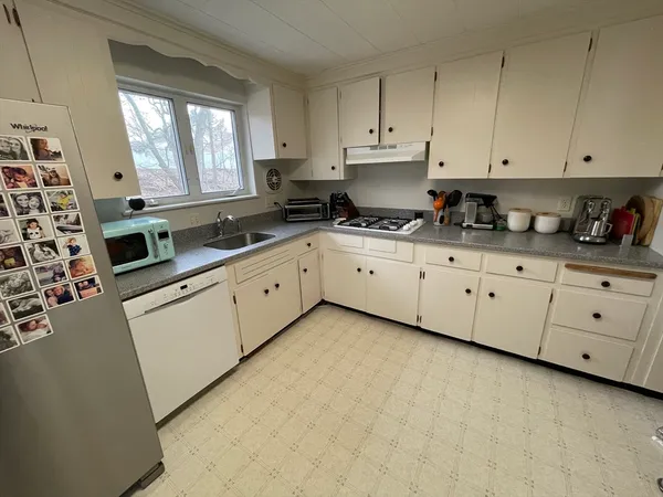a kitchen with cabinets appliances a sink and a window