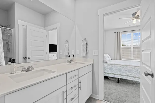 a en suite bathroom with double sink a mirror and a bathtub
