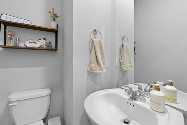 a bathroom with a sink a toilet and a mirror