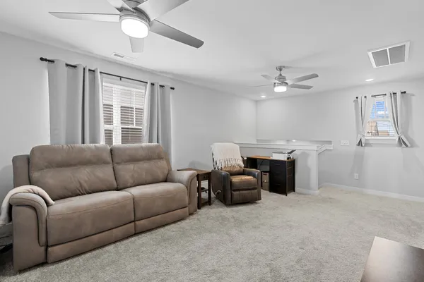 a living room with furniture and a chandelier