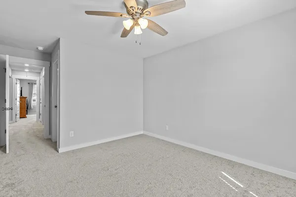 an empty room with a chandelier fan and closet