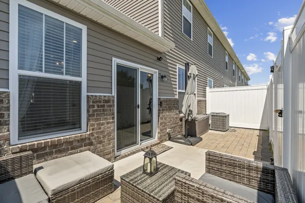 a view of a patio with couches chairs and wooden floor