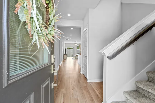 a view of a hallway with wooden floor and staircase