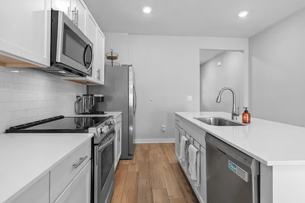 a kitchen with stainless steel appliances granite countertop a sink stove a refrigerator and cabinets